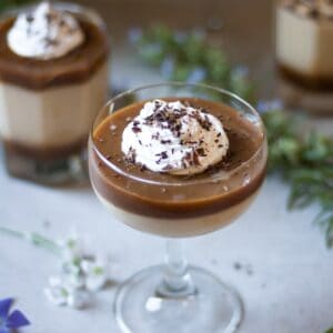 Butterscotch Pudding in a glass decorated with whipped cream and shredded chocolate
