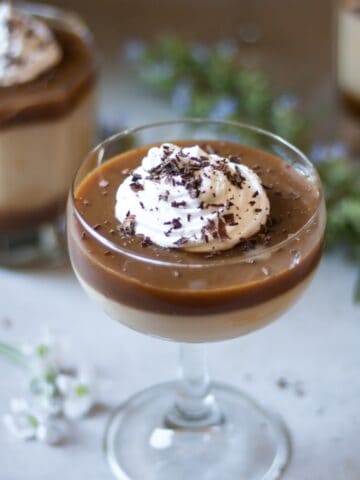 Butterscotch Pudding in a glass decorated with whipped cream and shredded chocolate