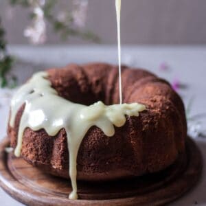 pouring white chocolate glaze over gluten-free bundt cake