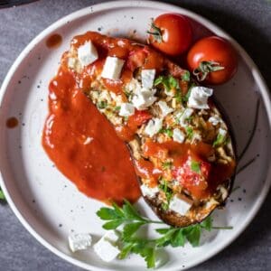 half an eggplant stuffed with veggies and drizzled with tomato sauce