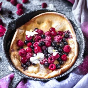 dutch baby in a skillet topped with berries