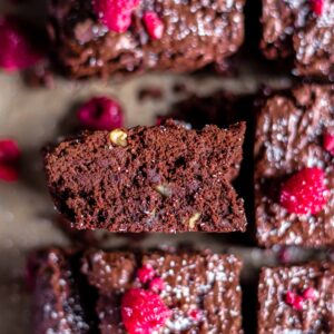 a slice of gluten-free brownies topped with fresh raspberries