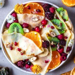 crepes on a plate served with fruit