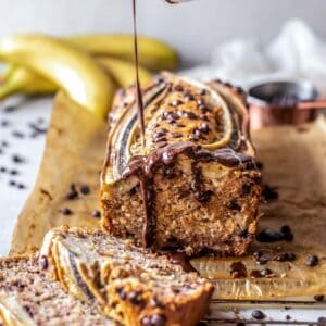 Sliced low FODMAP banana bread with a drizzle of chocolate sauce