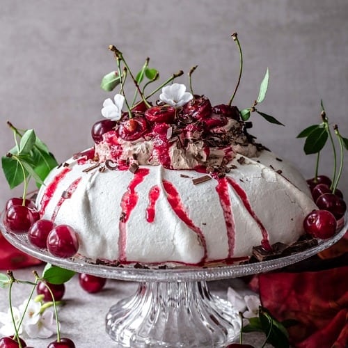 This Black Forest Pavlova is crunchy on the top, soft and marshmallowy in the middle, perfectly sweetened, chocolaty, cherry-infused and so delicious.