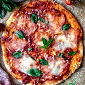gluten-free pizza crust with tomato, mozarella and fresh basil.