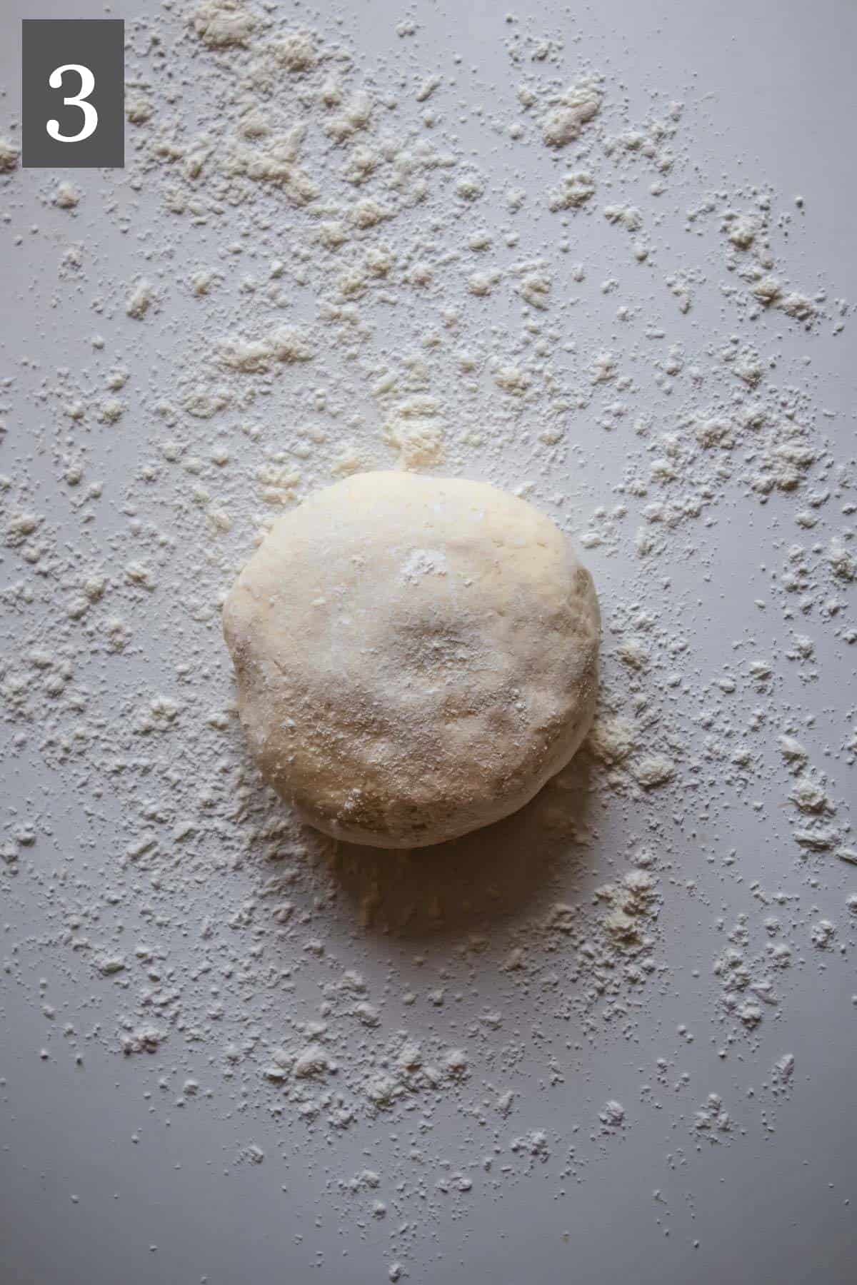 Pizza dough on a floured surface.