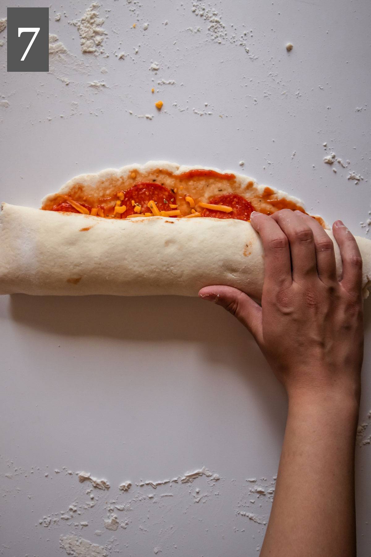 Rolling the pizza dough into a log.