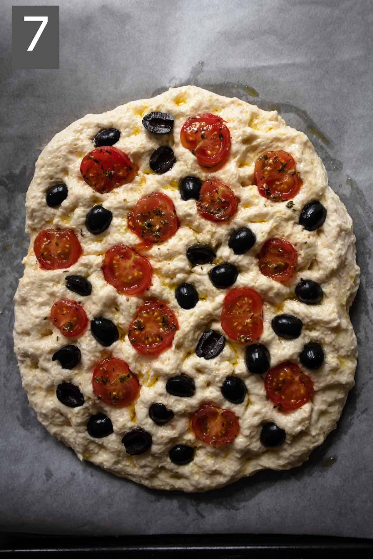 Focaccia with cherry tomatoes and olives before baking