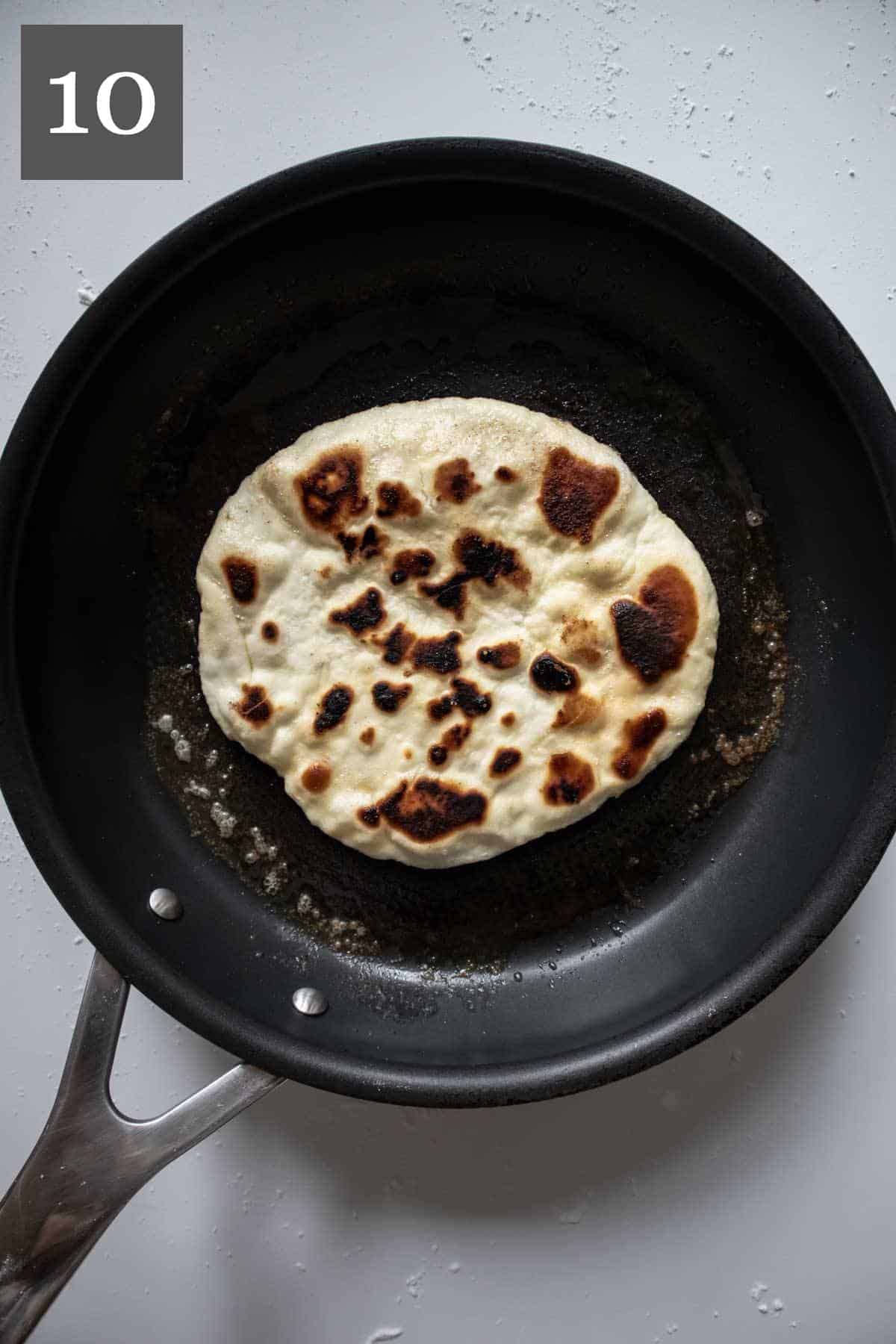 Bubbly gluten-free naan with big brown blisters.