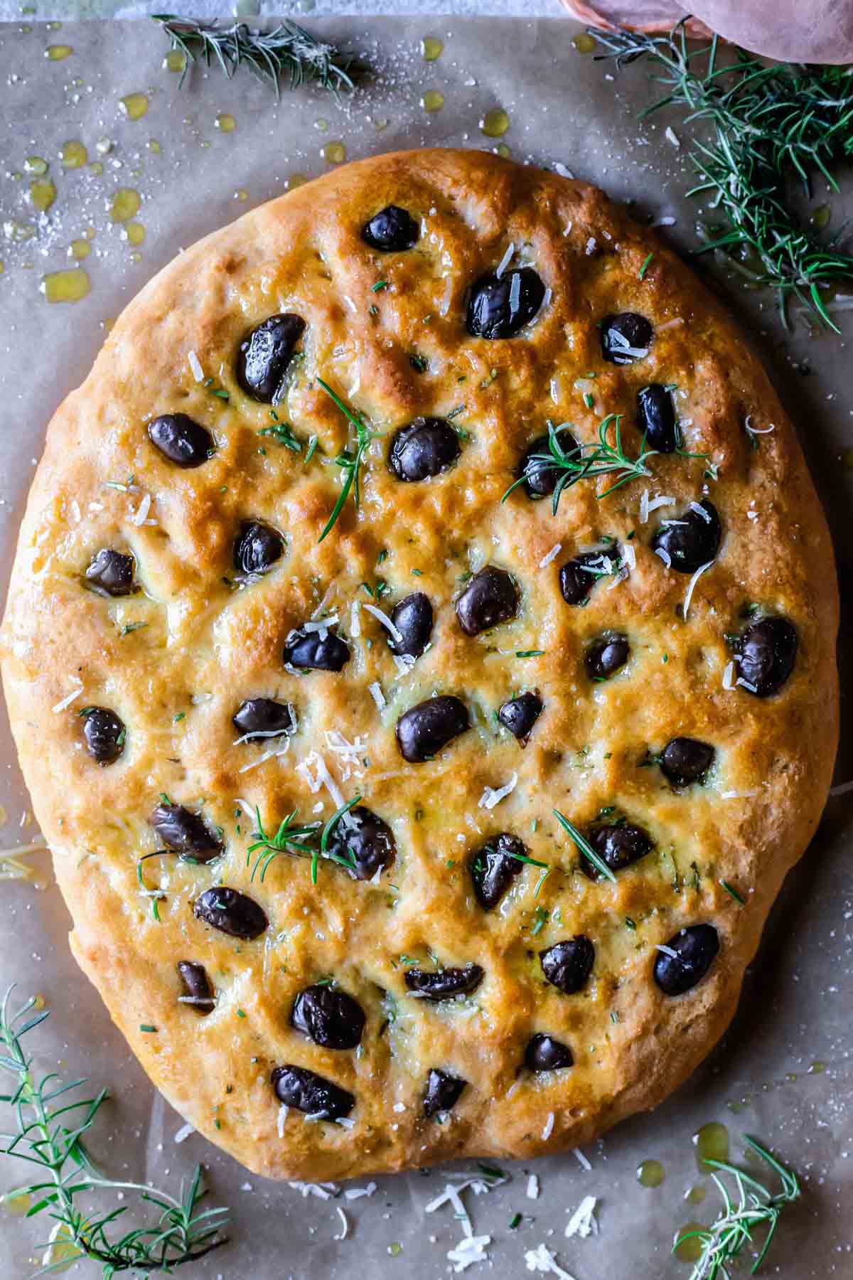 Baked focaccia topped with olives, rosemary and parmesan cheese. 