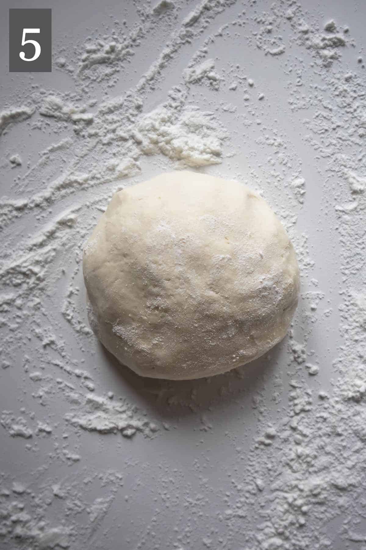 Gluten-free naan dough on a floured surface.