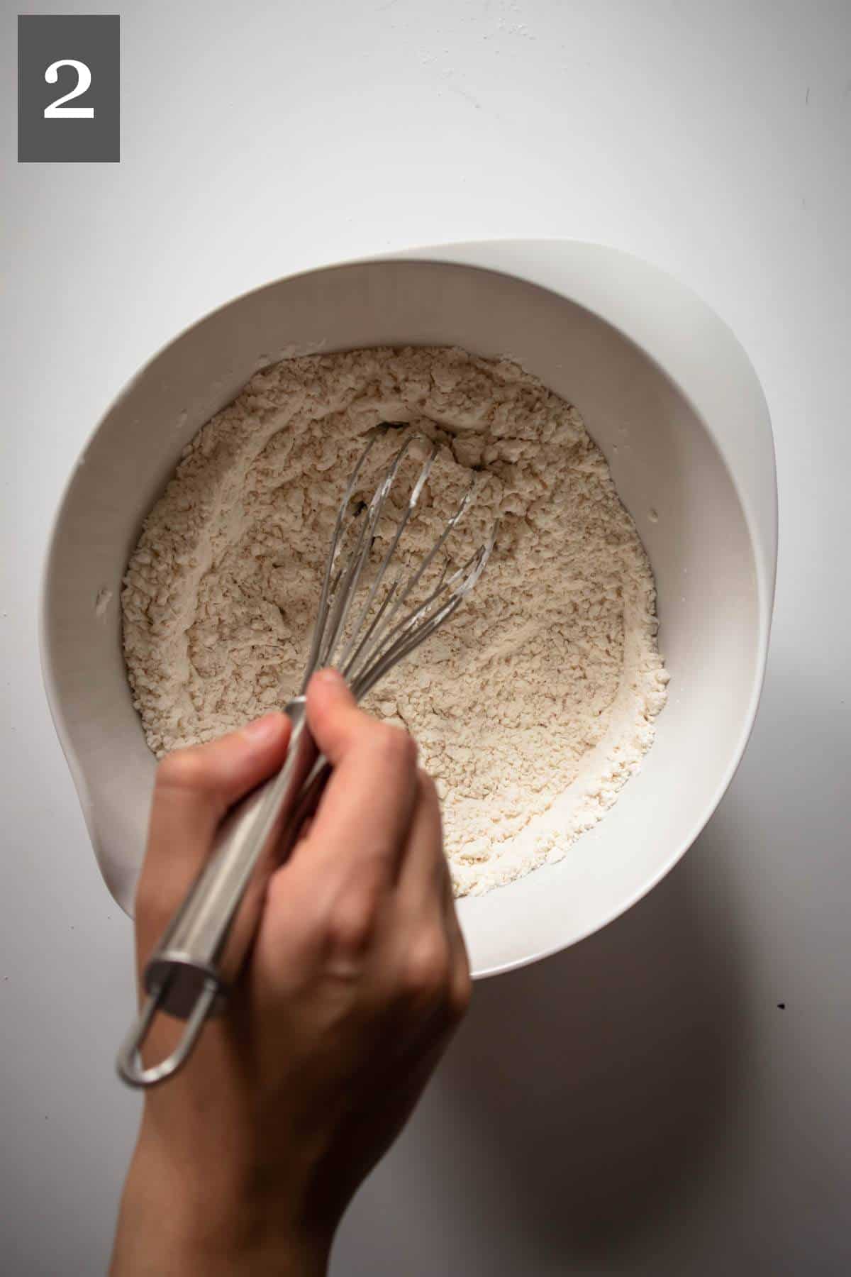 Mixing dry ingredients with a hand whisk.
