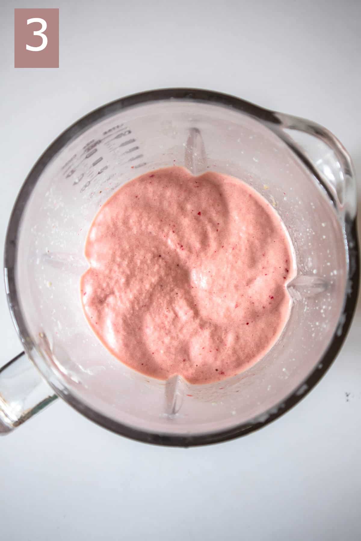 Thick and creamy pink smoothie in a blender.