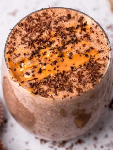 Smoothie in a glass decorated with chocolate and peanut butter