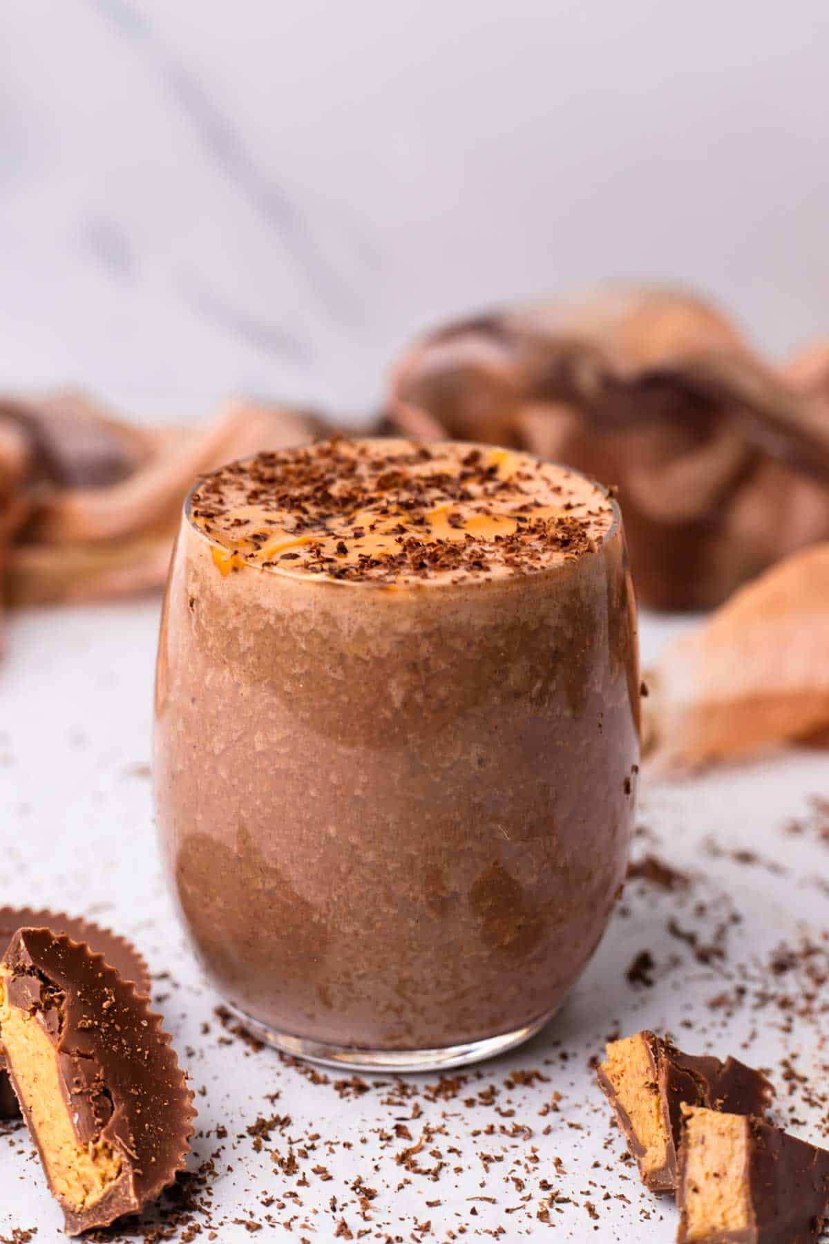 Smoothie in a glass peanut butter cups around it.