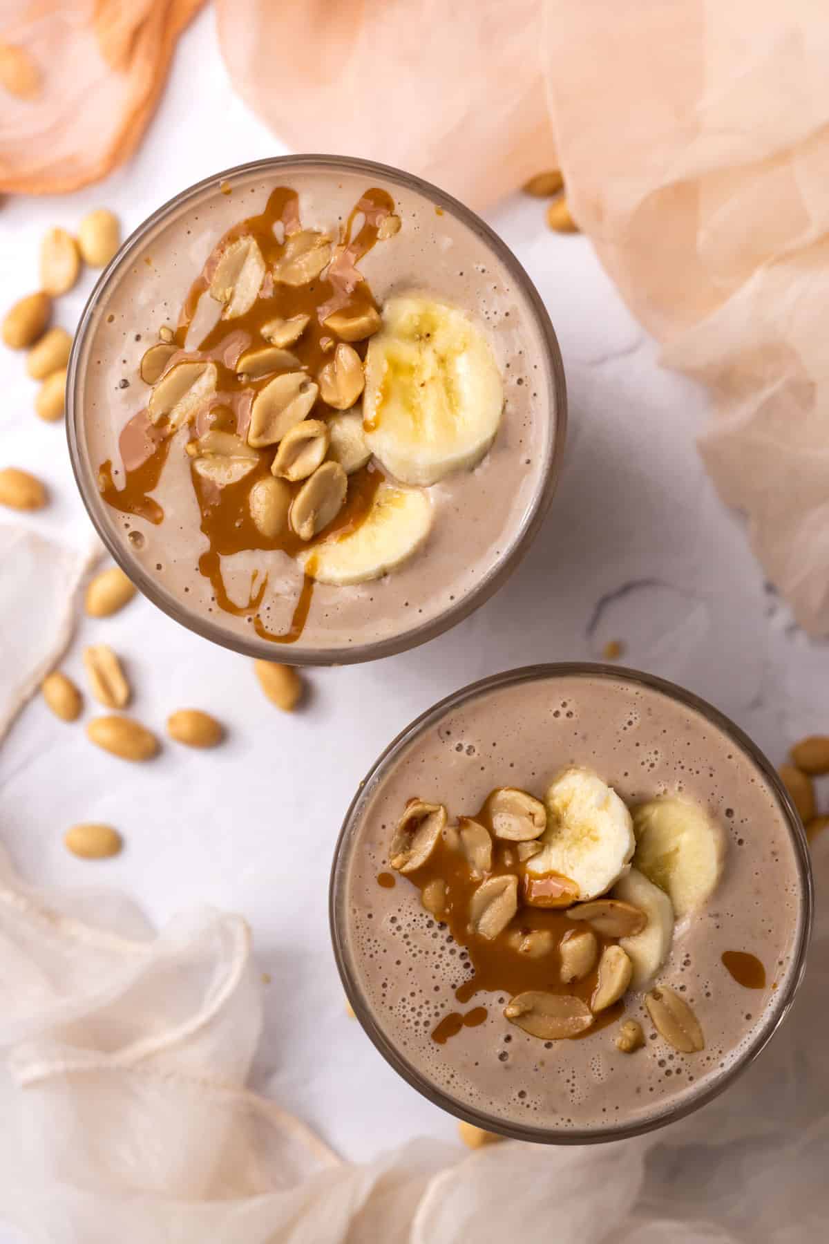 Two Peanut butter tropical smoothies photographed from above