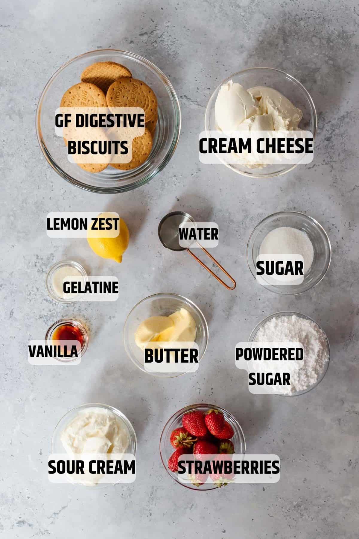 Ingredients for no-bake cheesecake on a grey stone surface.