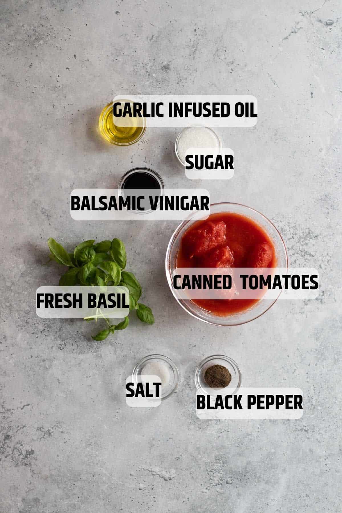 Ingredients for low FODMAP pasta sauce on a grey stone background.