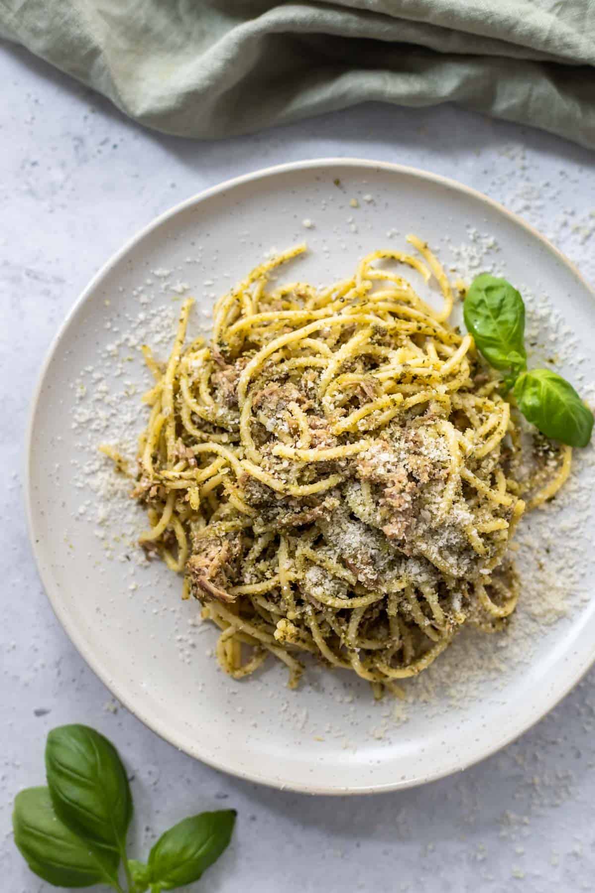 Tuna pesto pasta on a plate with parmesan cheese.