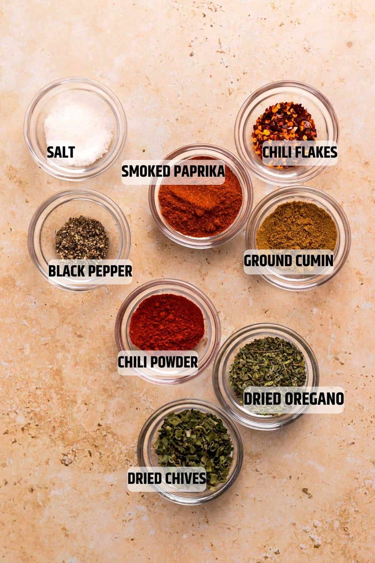Ingredients for low FODMAP Taco Seasoning on a sandstone background