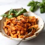 Low FODMAP Vodka Pasta in a bowl topped with chilli flakes and basil.