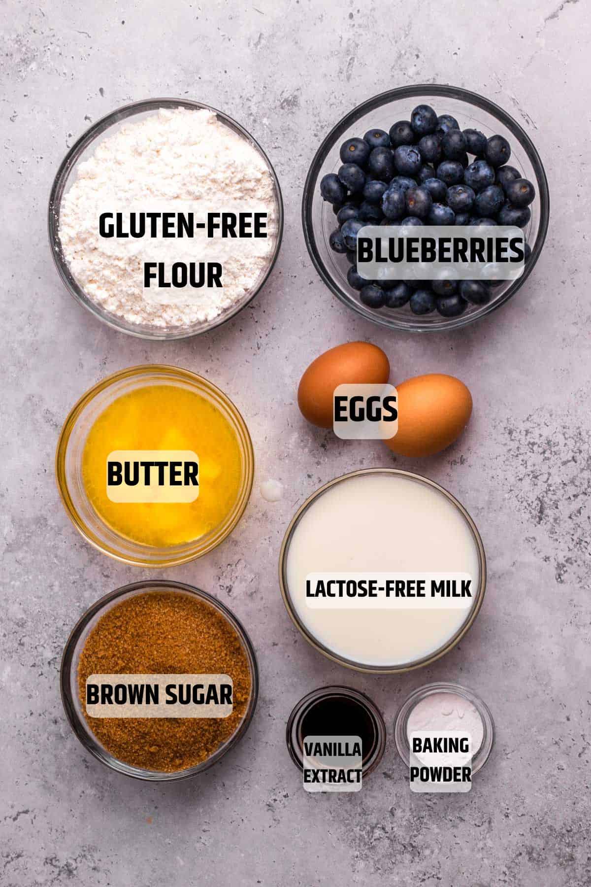 Ingredients for Low FODMAP Blueberry Muffins on a grey surface.