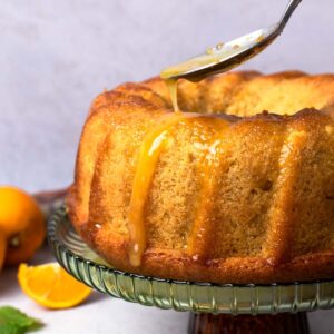 Italian Hangover Cake on a cake stand drizzled with a glaze