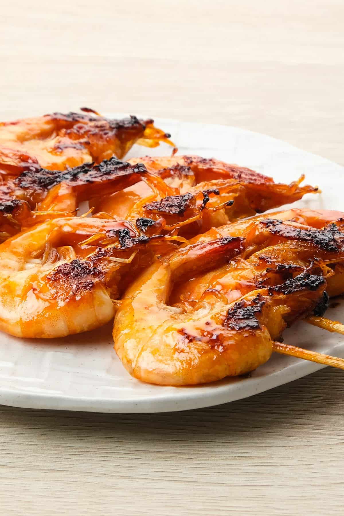 Grilled shrimp on the barbie served on a plate.