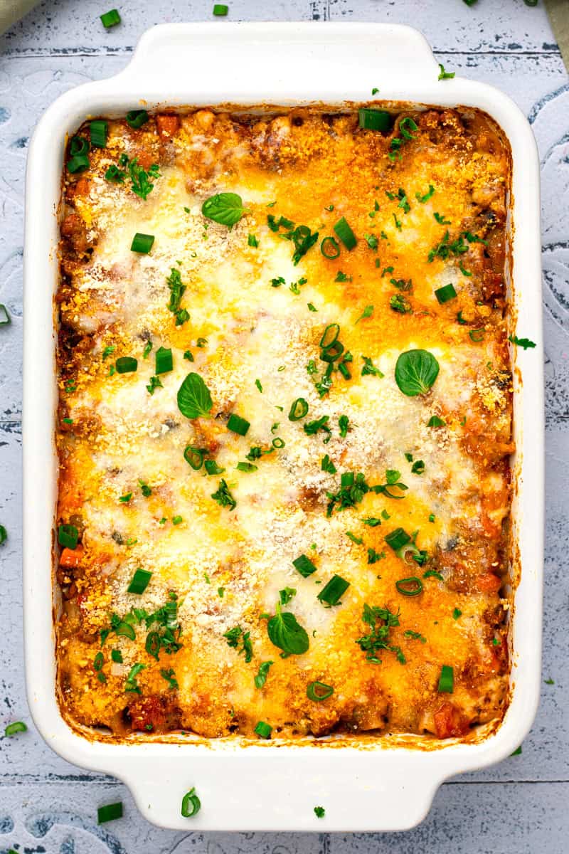 Low FODMAP lasagna in a baking dish with fresh basil