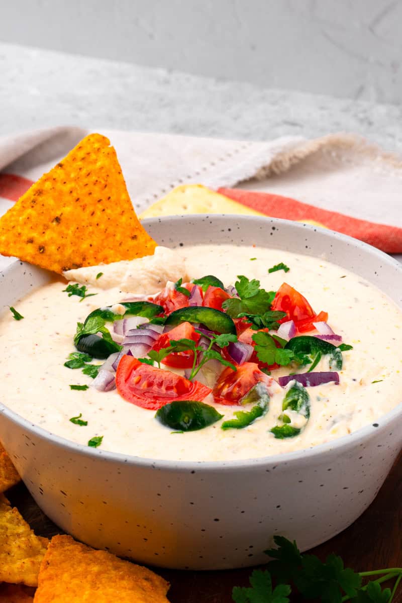 chip in a bowl of cottage cheese queso dip.